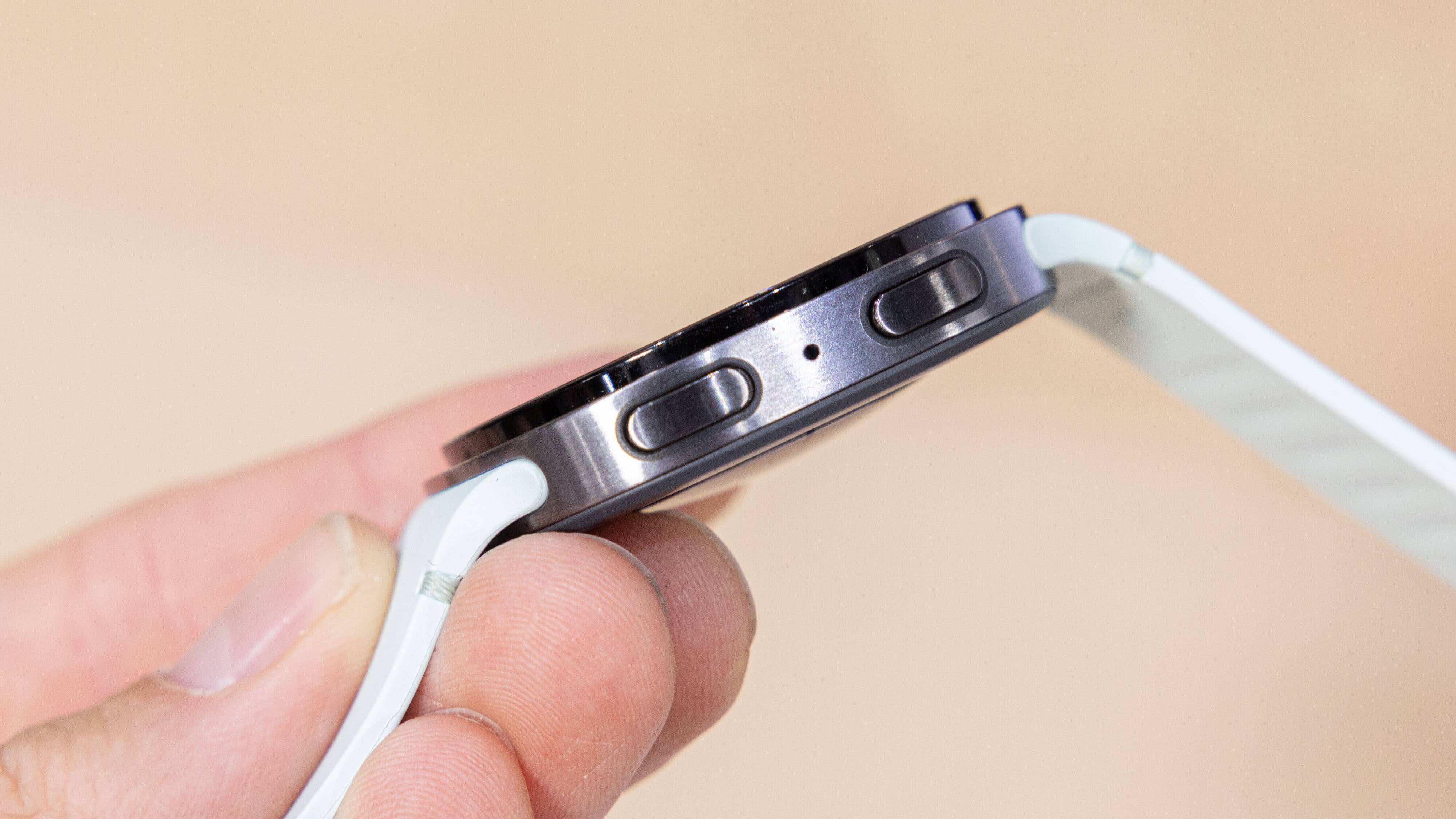 A Samsung Galaxy Watch 8 being held in a hand, showcasing its side buttons and sleek design.