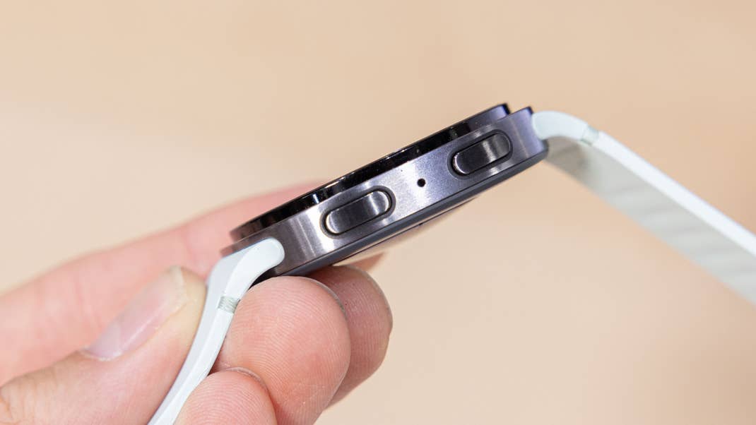 A Samsung Galaxy Watch 8 being held in a hand, showcasing its side buttons and sleek design.