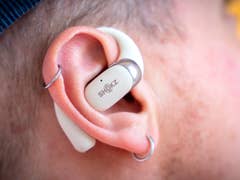 A close-up of Shokz OpenFit 2 wireless earphones resting in an ear.