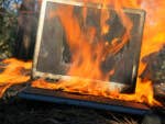 A burning laptop on the ground