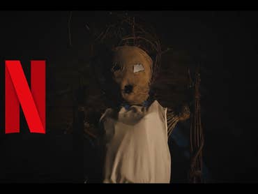 A straw doll and a Netflix-N against a black background