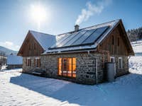 Residential building with PV modules in winter under sunlight with tank for liquid battery