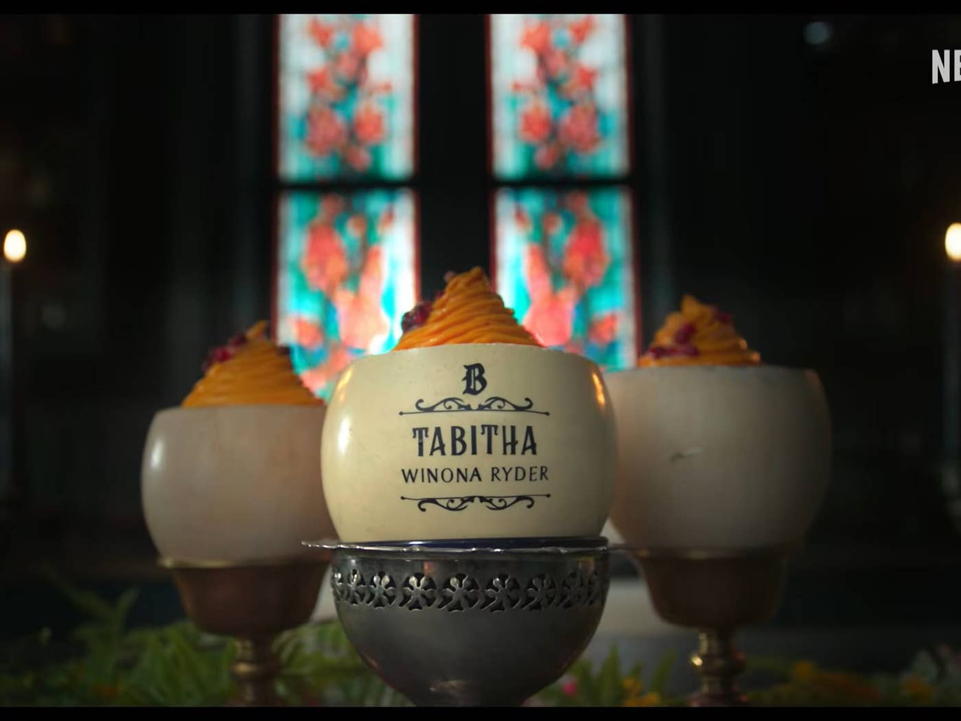 A jar surrounded by candles. The jar is labeled "Tabitha" and the name Winona Ryder