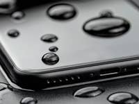 A smartphone with water droplets on its surface, showcasing water resistance.