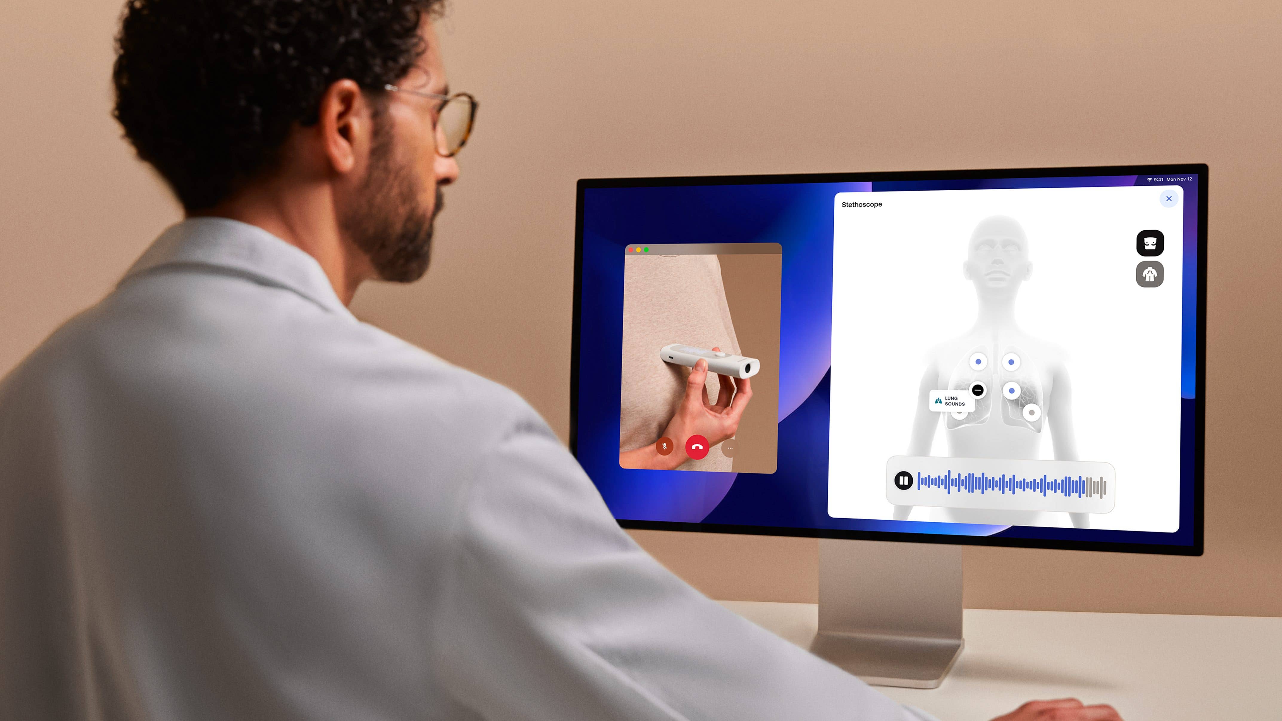 A doctor looking at a patient's health data on a desktop display A doctor looking at a patient's health data on a desktop display